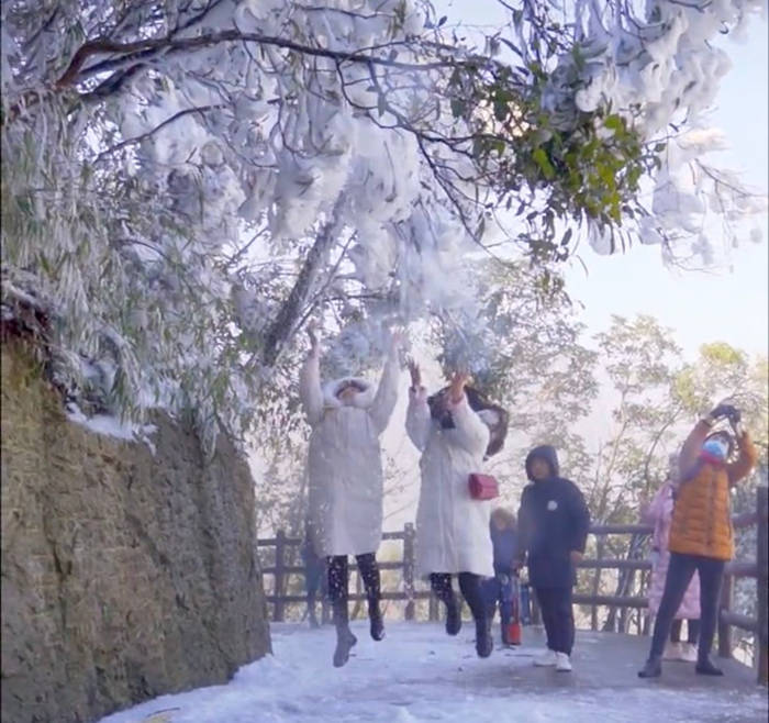 五指峰道路上玩雪的小姐姐和拍照的路人